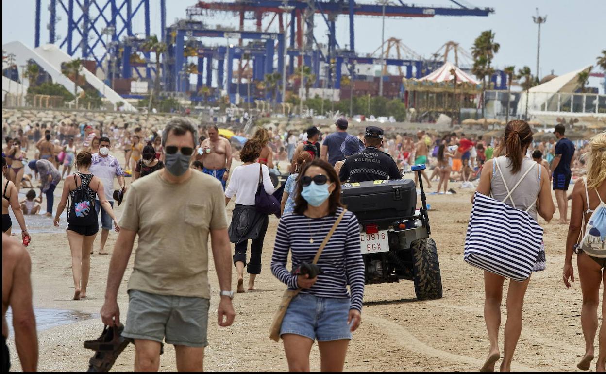 Bañistas con mascarilla en la playa de la Malvarrosa.