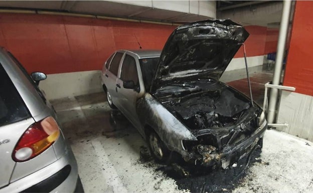 Imagen del coche incendiado en el centro comercial Gran Vía de Alicante. 