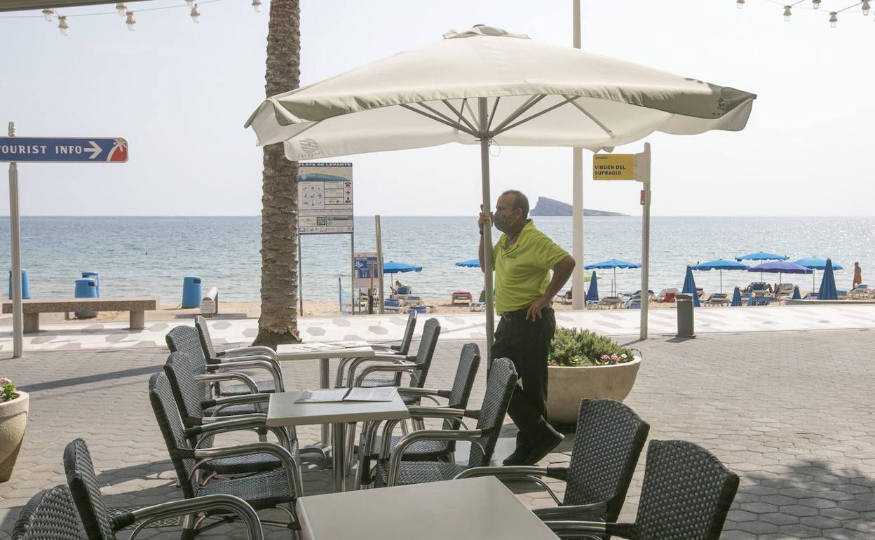 Un camarero espera la llegada de clientes en el paseo marítimo de Benidorm durante la pandemia. 