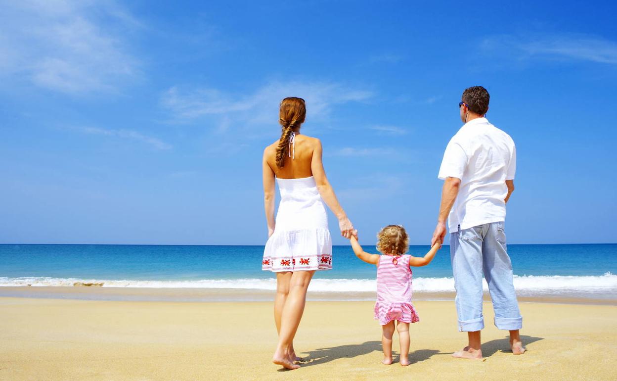 Una pareja y su hija, en la playa.