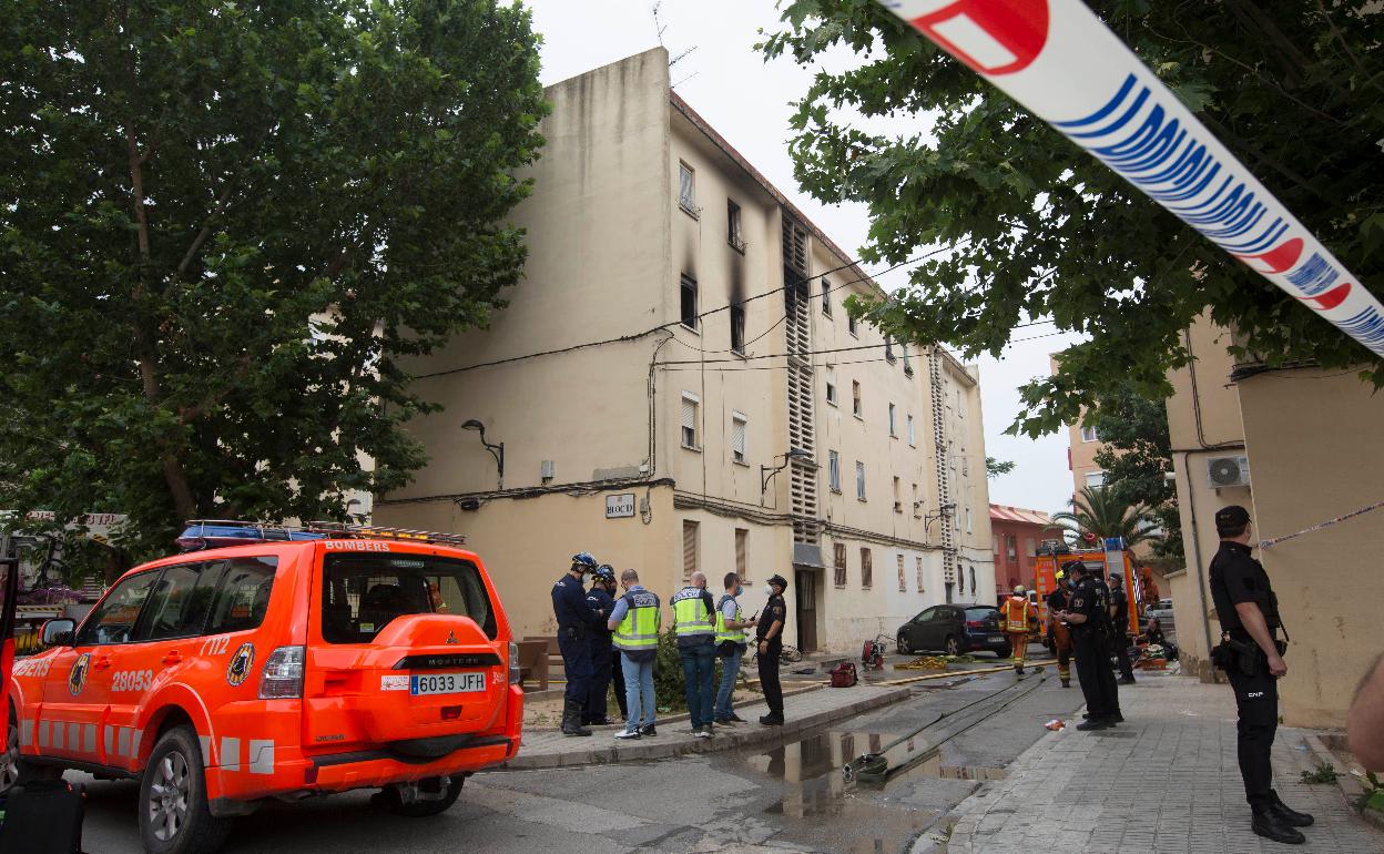 Bomberos y policía junto al bloque donde se produjo el incendio en Algemesí. 