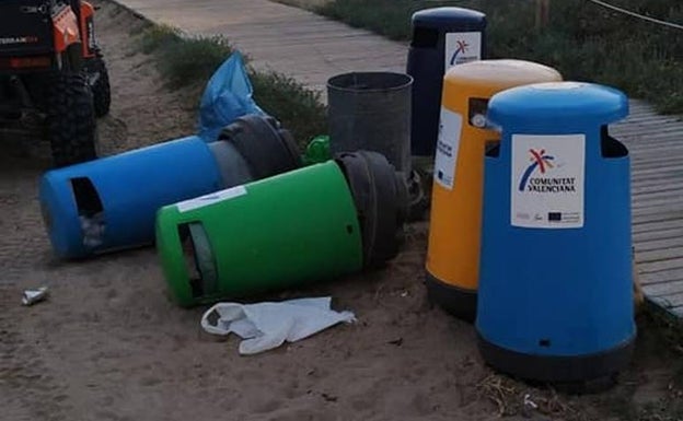 Papelera volcadas junto a la pasarela de acceso a la playa. 