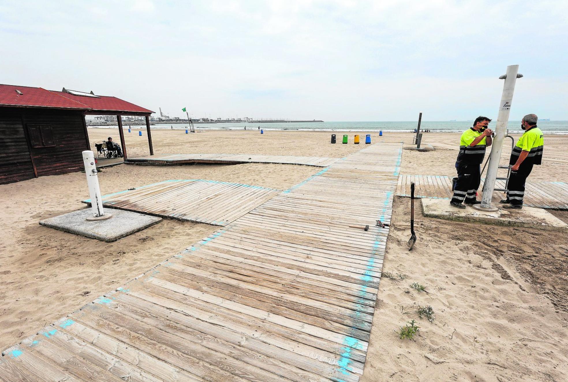  Operarios trabajan en la playa de Pinedo en Valencia. J. Signes