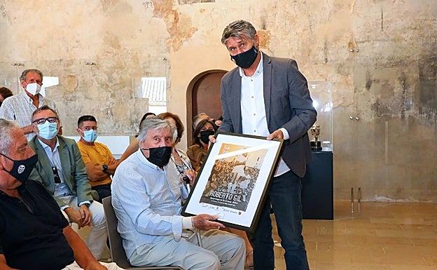 Miguel Tendillo hace entrega de un detalle a Roberto Gil. 