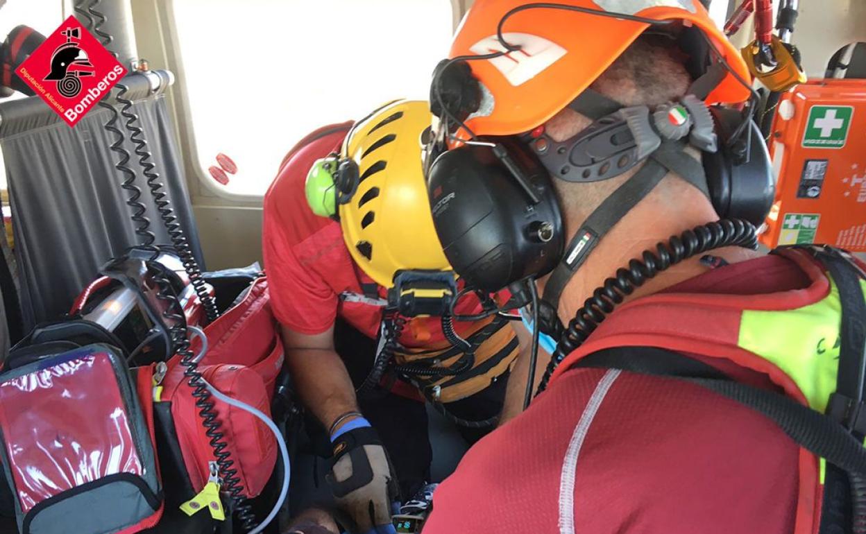 Los bomberos trasladan en helicóptero al ciclista herido. 