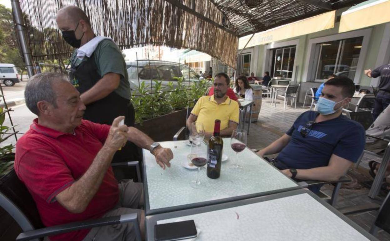 Cliente del restaurante 'Casa Teresa' De El Saler aplicándose un producto repelente de mosquitos. 