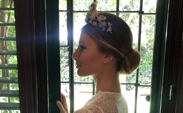 Claudia Pilatos lleva una tiara de flores con un recogido bajo desaliñado, con mechas balayage.