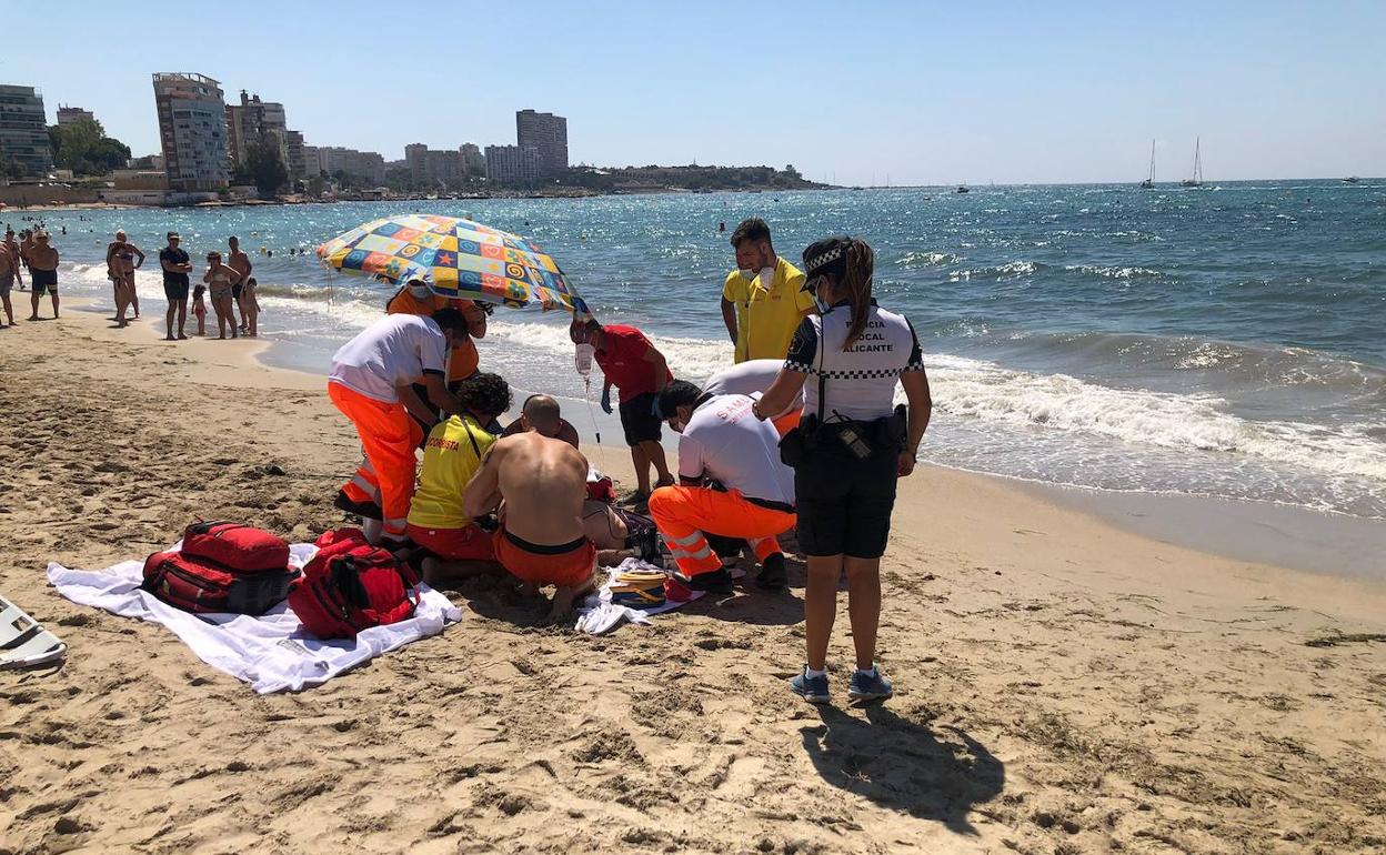 Intervención de los sanitarios para estabilizar al bañista, este domingo en La Albufereta de Alicante. 