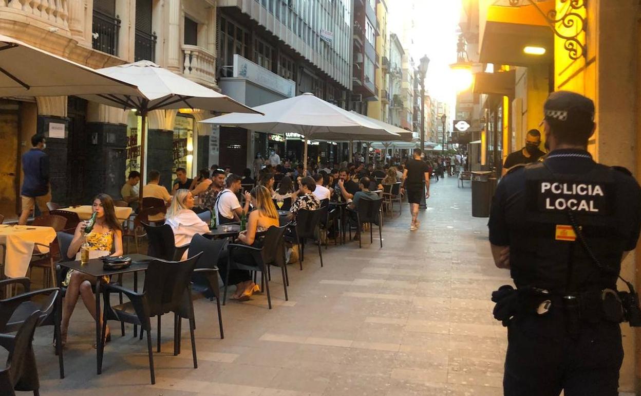 Un policía local supervisa el cumplimiento de las normas en locales de ocio del centro de Alicante. 