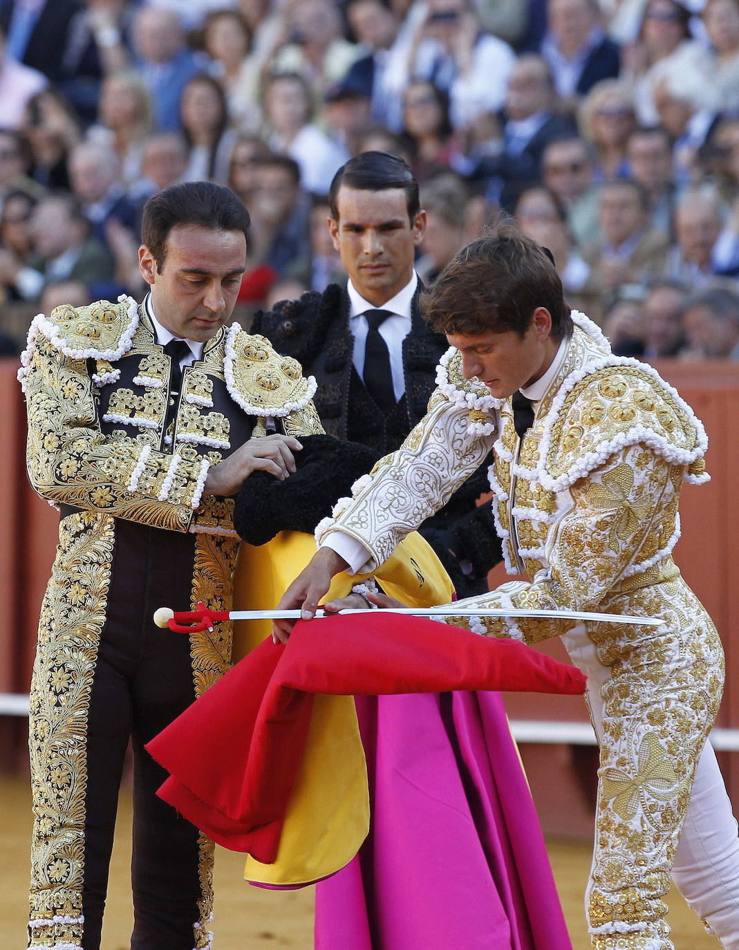 El diestro Lama de Góngora (d) toma la alternativa de manos de Enrique Ponce (i), en presencia de José Mari Manzanares, durante la sexta corrida de la Feria de Abril de Sevilla en la Plaza de Toros de la Maestranza, en 2015