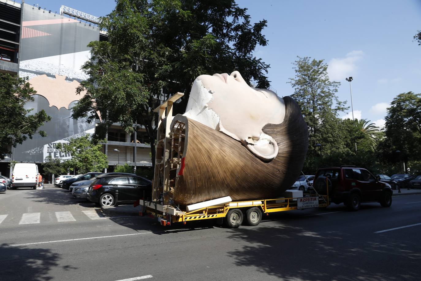 El busto de la falla municipal 2020 sale de la antigua base del Alinghi en La Marina para su restauración. 