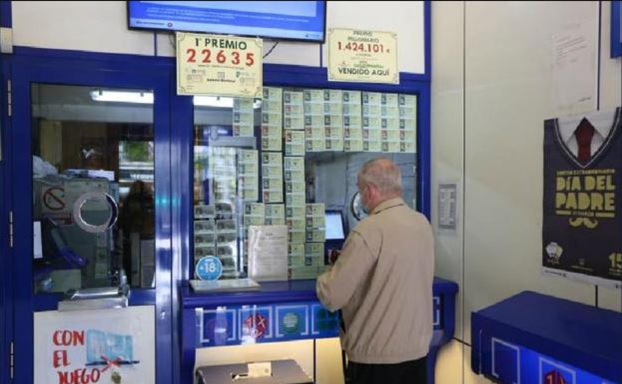 Un hombre sella sus boletos en una administración de lotería.