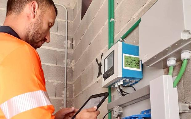 Operario cogiendo una muestra de agua y registrándola en el sistema