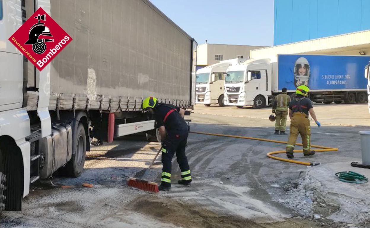 Los bomberos trabajan en la retirada del gasoil de la vía. 