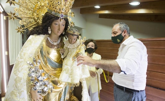 Francisco Perales toma medidas a la talla de la Mare de Déu mientras es observado por la camarera de la Virgen, María Dolores Alfonso. 