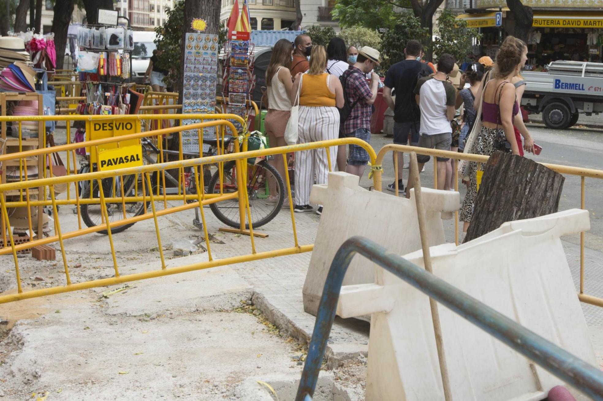 El centro en obras. Turistas se abren paso entre las obras de plaza de la Reina y junto a la Lonja. 