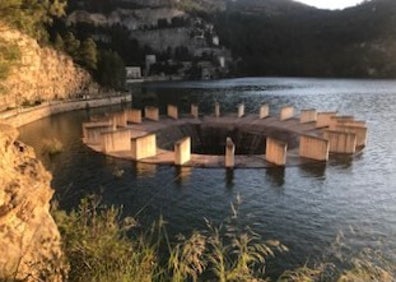 Imagen secundaria 1 - Arriba, visión panorámica del pantano de Benagéber. Abajo a la izquierda, el aliviadero de la presa. A la derecha, casa de madera situada en un pequeño islote del pantano. 