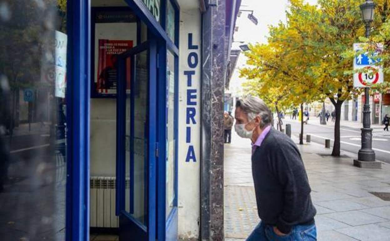 Un hombre entra a una administración de Loterías y Apuestas del Estado. 