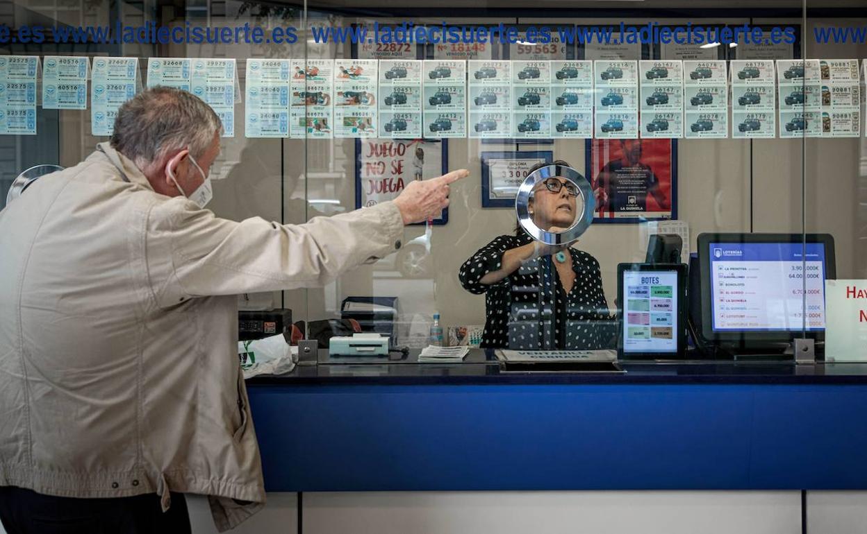 Un hombre compra lotería en una administración. 