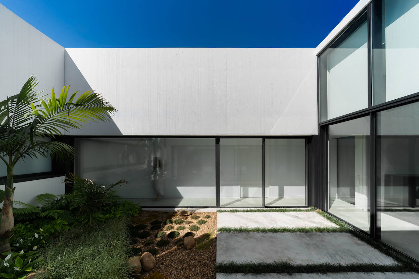 Un jardín interior permite la ventilación cruzada y se une al salón como si formara parte de él.