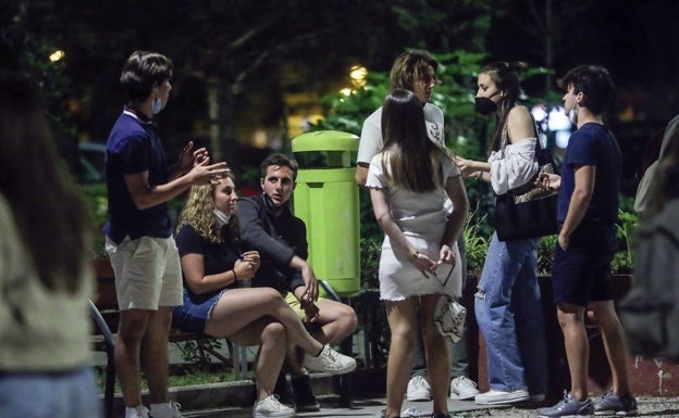 Un grupo de jóvenes conversa en la calle. 