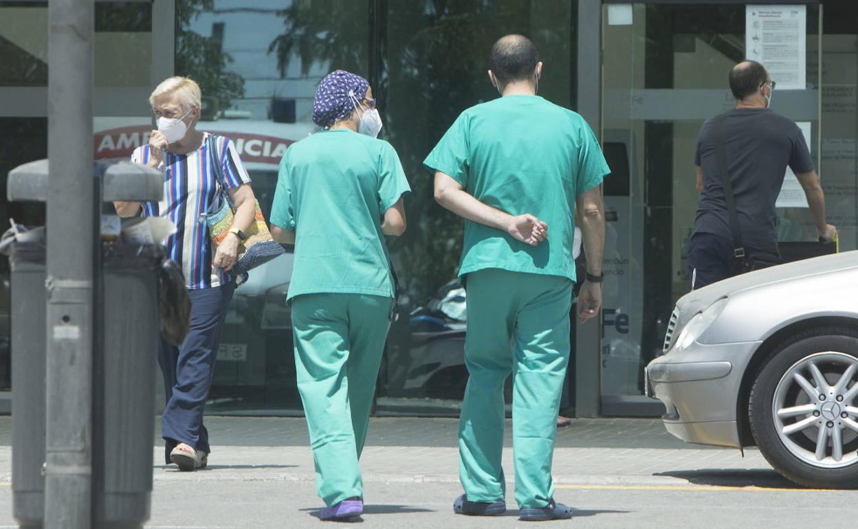 Personas sanitarios y usuarios en el acceso a un hospital valenciano.