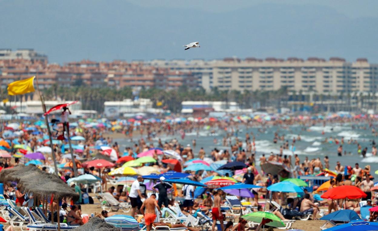 Una playa de Valencia, repleta de gente. Manuel Bruque / EFE
