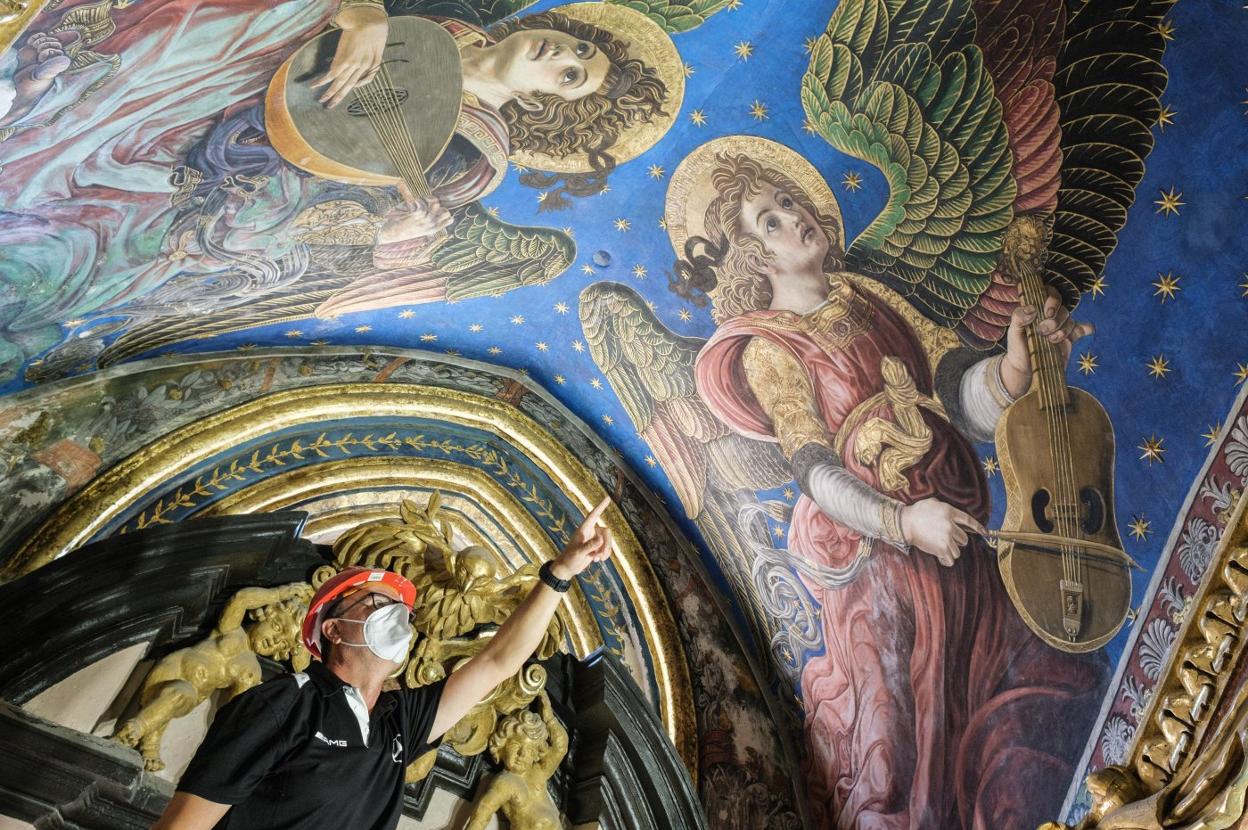 Uno de los restauradores señala los frescos de la catedral . V. Gutiérrez/AVAN
