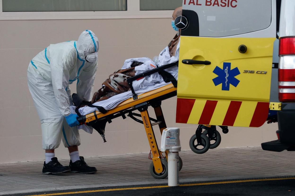 Un sanitario traslada a un enfermo en el Hospital Clínico de Valencia. EFE