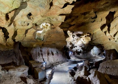 Imagen secundaria 1 - Ariba, un grupo de personas explora en barca las cuevas de San José. Abajo a la derecha, tramo de la galería seca, por donde los visitantes caminan. Abajo a la derecha, 'la cara del diablo' una formación en la roca similar a un rostro. 