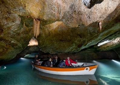 Imagen secundaria 1 - Arriba, una kayakista recorre las galerías de las cuevas. Abajo a la izquierda, un barquero guía a un grupo por las grutas. Abajo a la derecha, un kayakista observa el techo de las cuevas. 