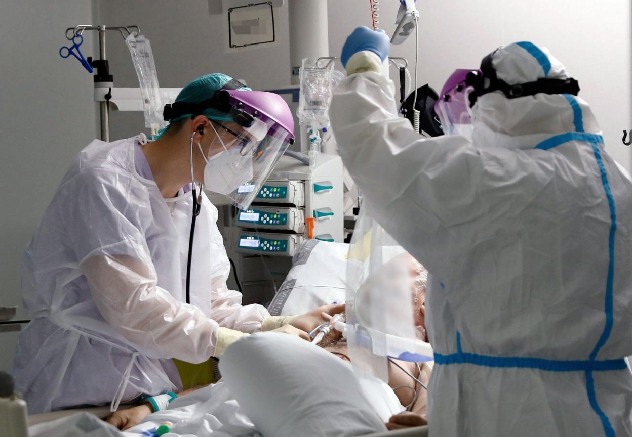 Sanitarios atienden a un paciente en una UCI valenciana. efe/j. c cárdenas