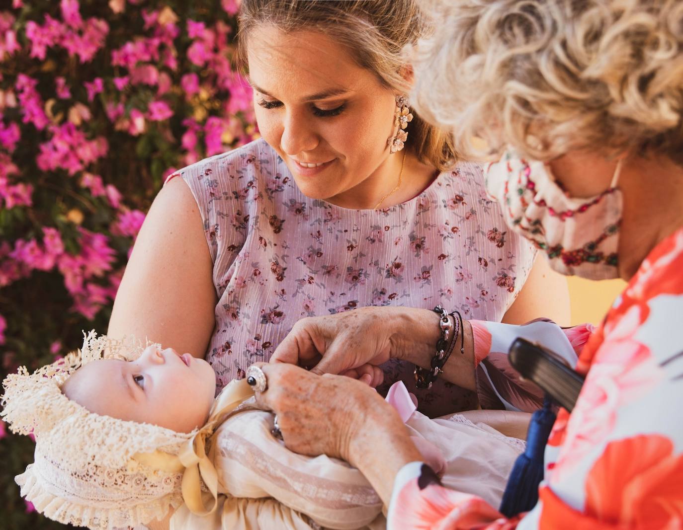 Marta de Diego con su hija Casilda y su nieta poniendo la medalla regalo de madrina 