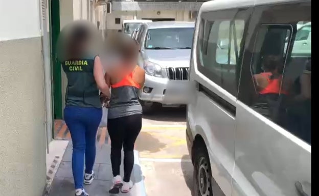 Una guardia civil traslada a la detenida. 