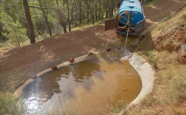 Imagen principal - Una cuba llena de agua una de las balsas. 