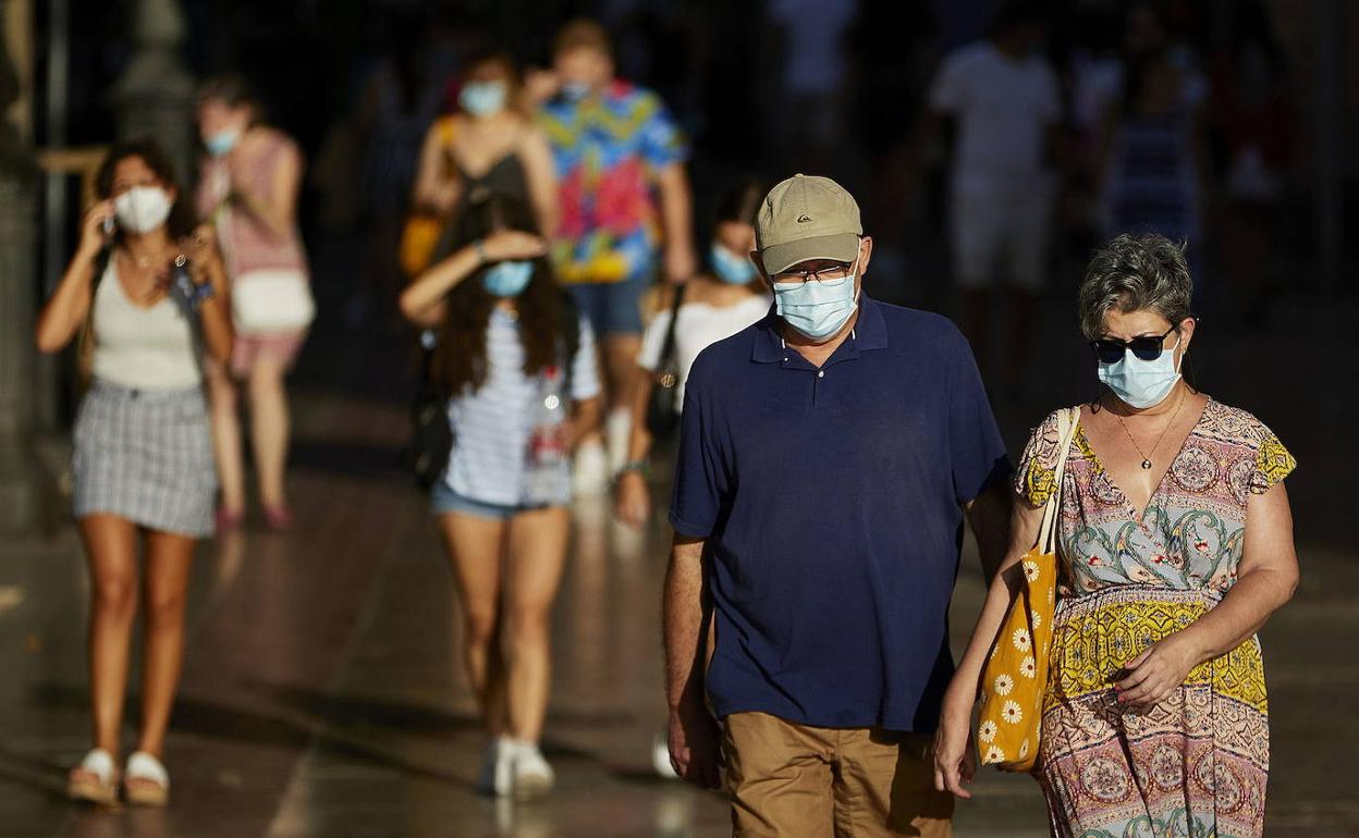 Varias personas caminan por una acera de la calle Xàtiva de Valencia. 