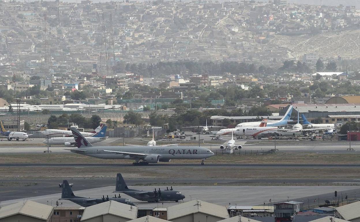 Un avión comercial se dispone a despegar ayer de Kabul junto a dos aernonaves militares de Estados Unidos.