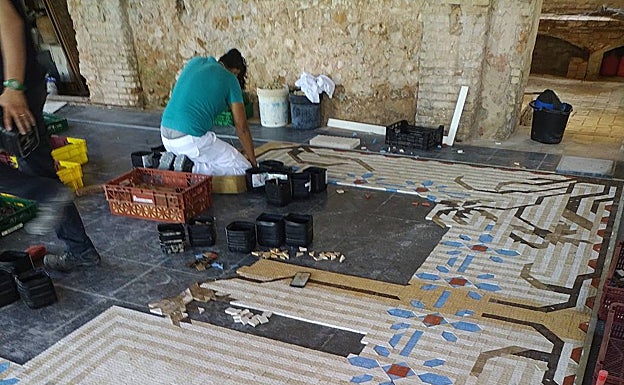 Un operario trabaja en el montaje de un suelo en el taller. 