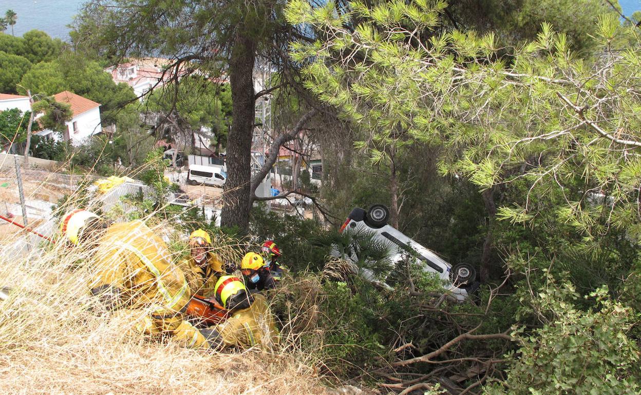 Los bomberos rescatando al hombre del coche con el que se había precipitado en Les Rotes. 