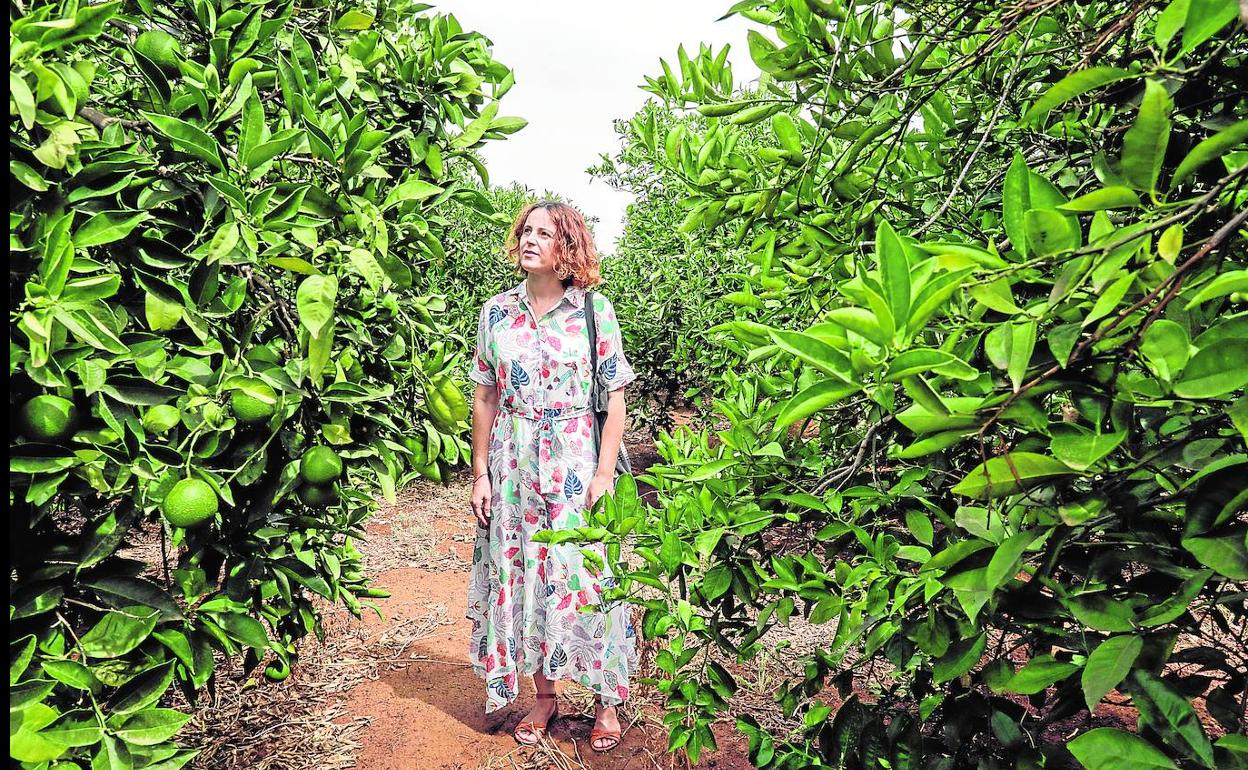 Lina camina entre cítricos.