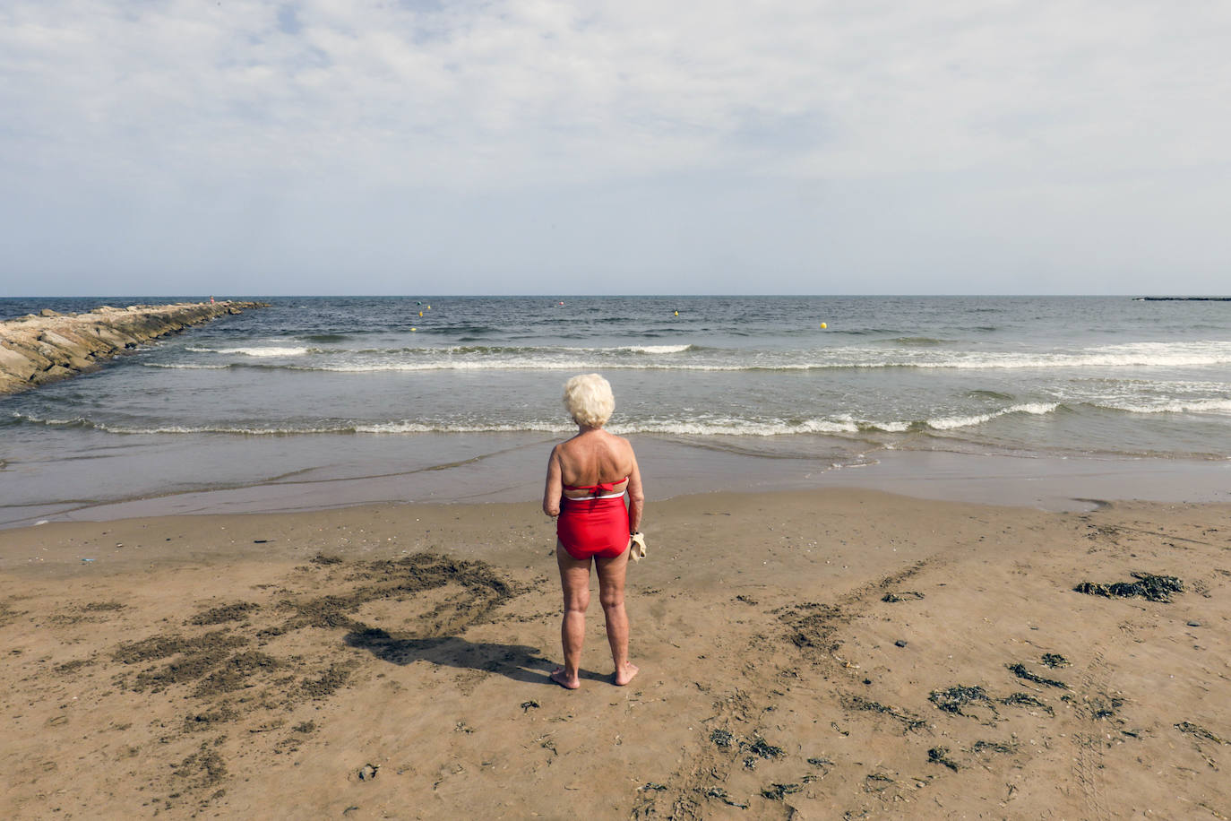 Una mujer contempla el mar. 