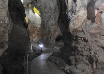 Imagen secundaria 1 - Arriba, la entrada a la Cueva de las Calaveras. Abajo a la izquierda, la plataforma de madera que discurre por el interior de la gruta. Abajo a la derecha, la estalactita apodada 'la Campana'. 