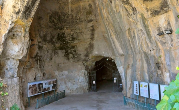 Imagen principal - Arriba, la entrada a la Cueva de las Calaveras. Abajo a la izquierda, la plataforma de madera que discurre por el interior de la gruta. Abajo a la derecha, la estalactita apodada 'la Campana'. 