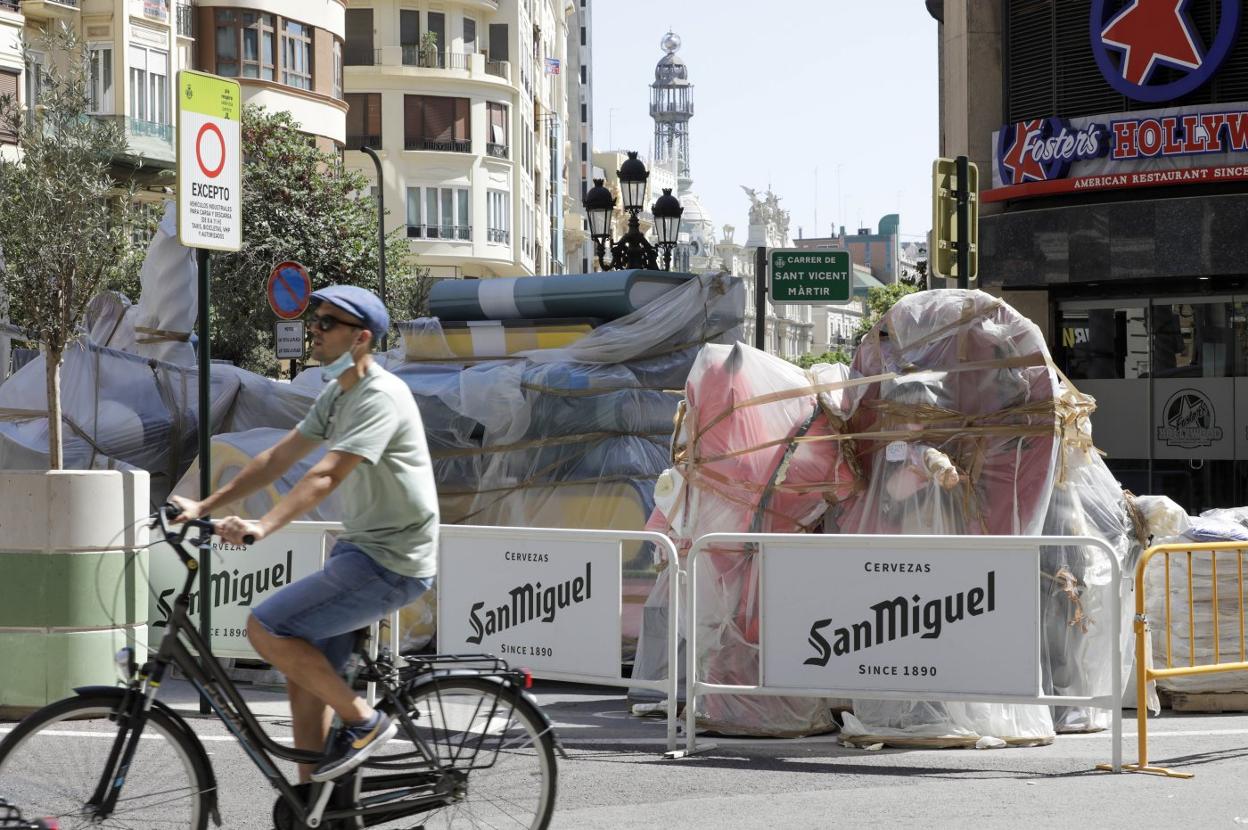 Un ciclista pasa ayer junto a la falla de la plaza del Mercat. irene marsilla
