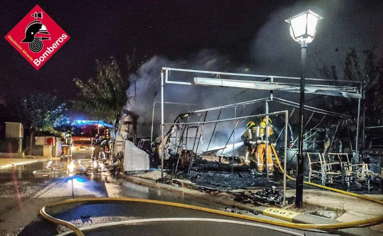 Intervención de los bomberos en las caravanas afectadas en el incendio, este sábado en Benidorm. 