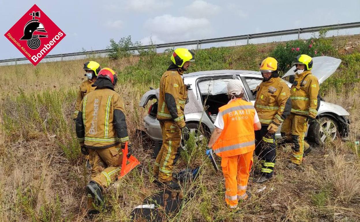 Efectivos del parque comarcal de bomberos y del SAMU junto al coche. 