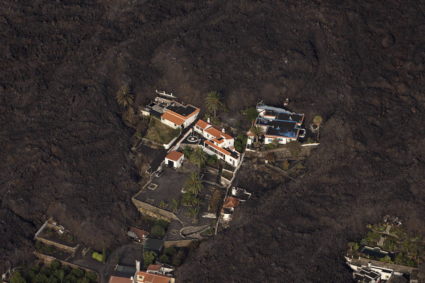 Hogares abandonados en mitad de la lava desprendida del volcán.