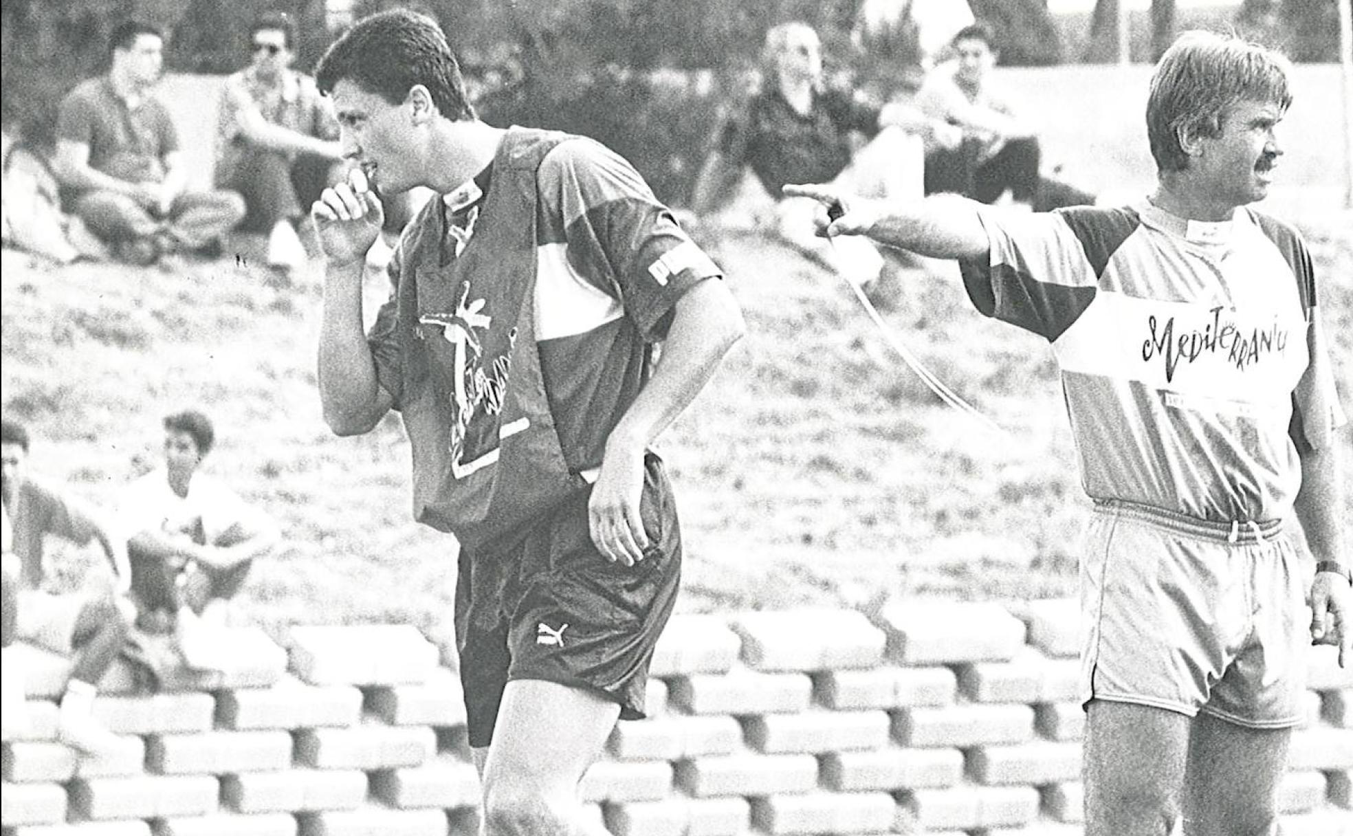 Guus Hiddink, junto a Lubo Penev, hace una indicación durante un entrenamiento en la ciudad deportiva, con aficionados sentados junto al campo.