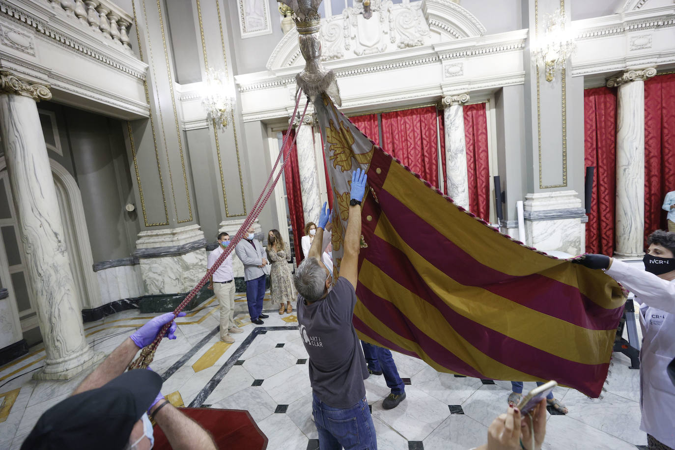 Cuatro meses de restauración devuelven el brillo a la enseña de 1928, que procesionará el 9 d'Octubre. Los expertos comprueban que el azul grisáceo que corona la pieza responde al mismo tono que muestra la bandera del siglo XVI