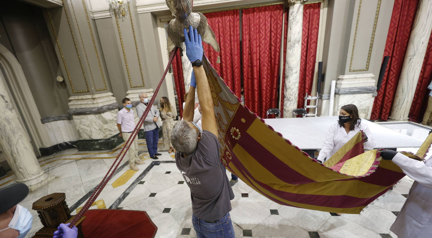 Cuatro meses de restauración devuelven el brillo a la enseña de 1928, que procesionará el 9 d'Octubre. Los expertos comprueban que el azul grisáceo que corona la pieza responde al mismo tono que muestra la bandera del siglo XVI